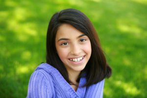 smiling girl sitting on grass